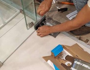 Técnico reparando una cortina metálica en un local comercial